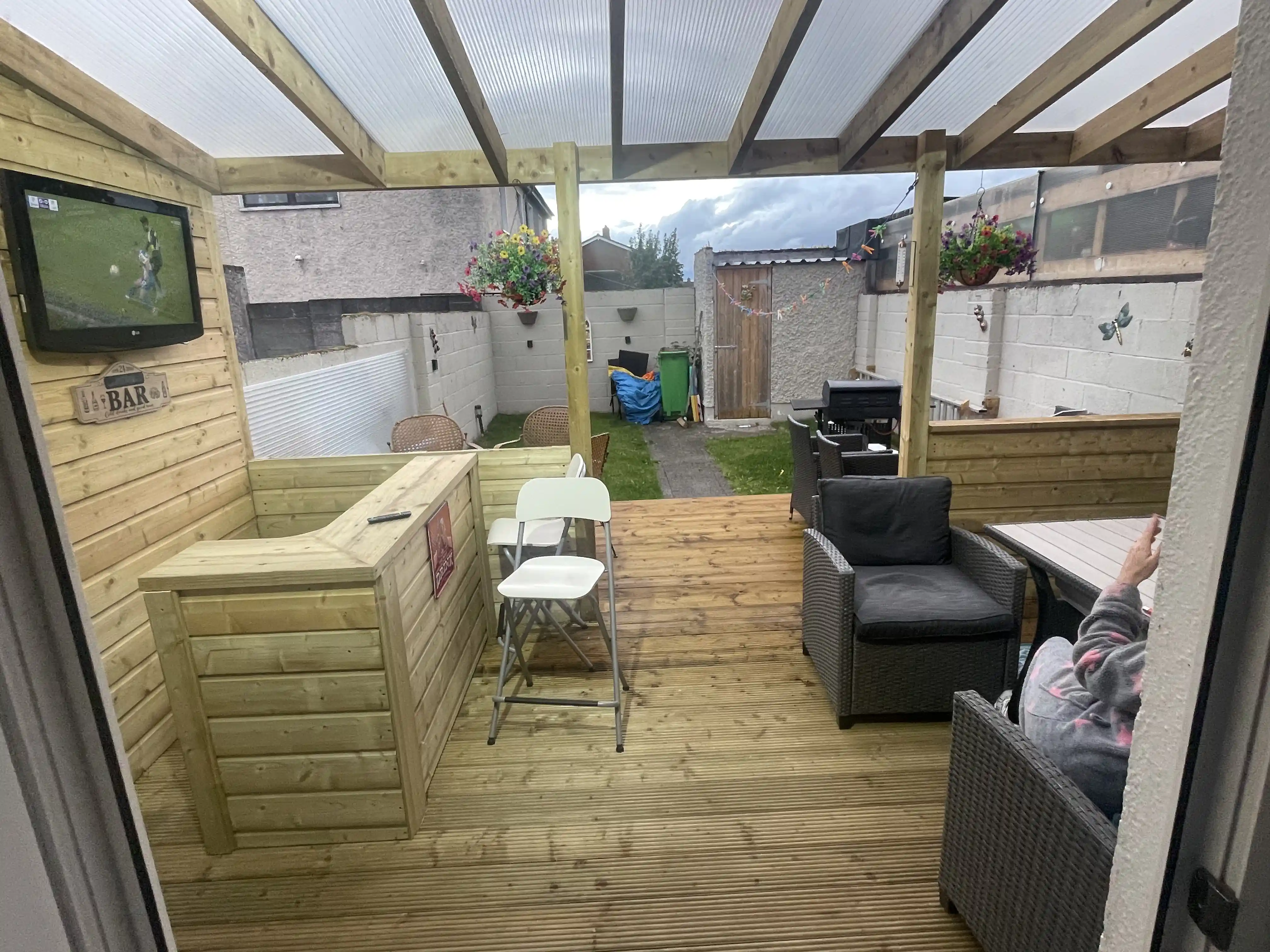 Modern outdoor lounge pergola with bar setup and entertainment area - professional Dublin installation